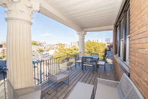 a balcony with a table and chairs and a view of the city