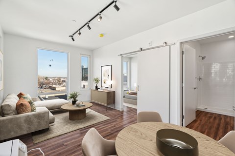 A modern living room with a grey couch and a wooden table.