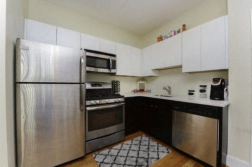 A kitchen with a stainless steel refrigerator, oven, and dishwasher.