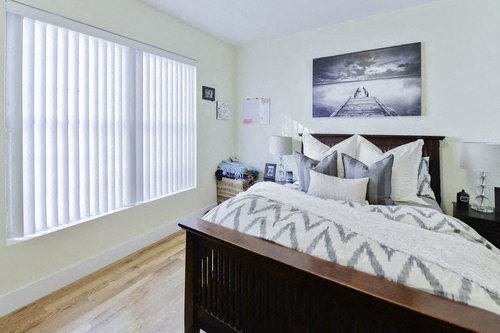 A bedroom with a large bed and a painting on the wall.