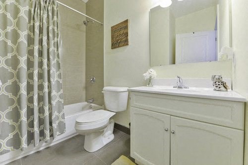 A white toilet sits next to a sink in a bathroom.
