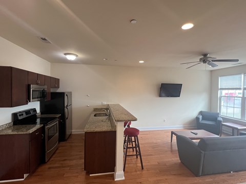 A kitchen with a refrigerator, microwave, and oven.