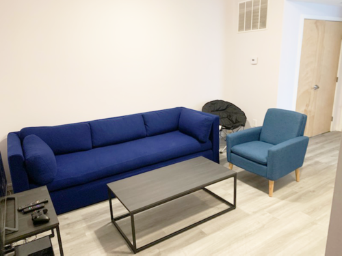 A blue sofa and matching chair are in a room with a coffee table.