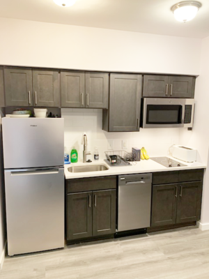 A kitchen with a stainless steel refrigerator and microwave.