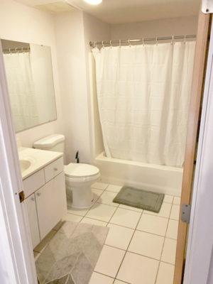 A white bathroom with a toilet, sink, and shower curtain.