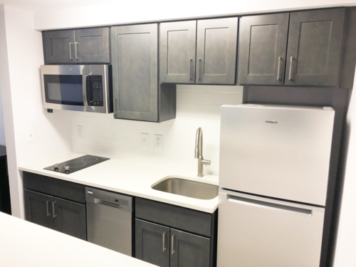 A white fridge and microwave are on a kitchen counter.