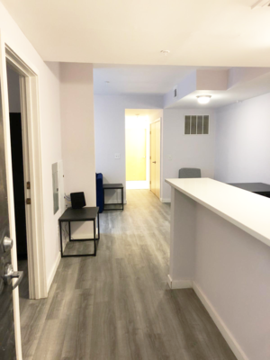 A hallway with a bench and a door.