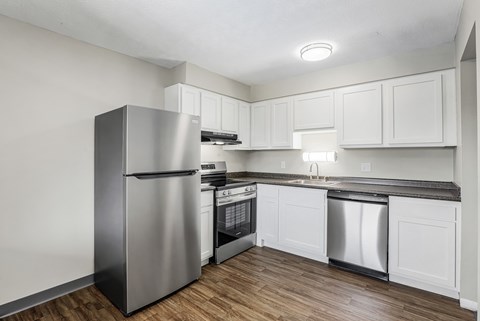 A kitchen with a stainless steel refrigerator, oven, and dishwasher.