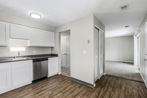 A kitchen with white cabinets and a black countertop.