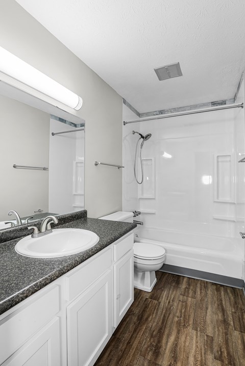 A white bathroom with a sink, toilet, and bathtub.