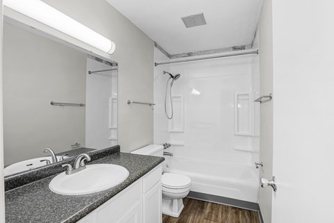 A white bathroom with a sink, toilet, and bathtub.