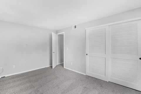 A room with a carpeted floor and white walls.
