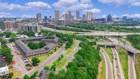 A cityscape with a highway and buildings in the background.