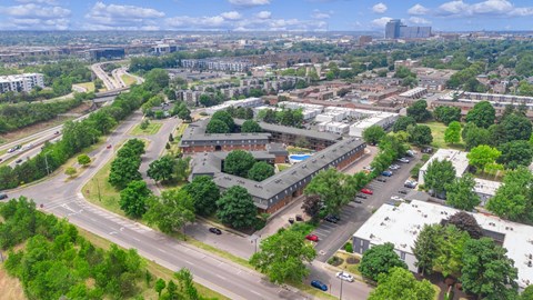 A bird's eye view of a city with a mix of greenery and buildings.