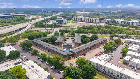 A bird's eye view of a city with roads, buildings, and cars.