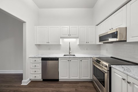 a kitchen with white cabinets and stainless steel appliances