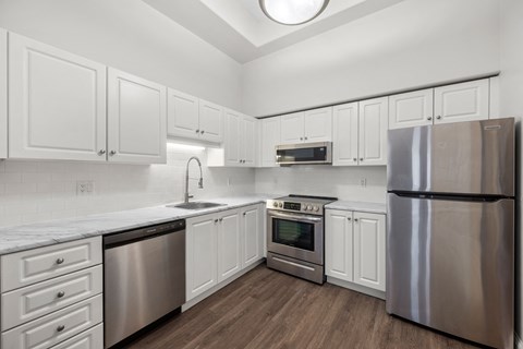 a kitchen with white cabinets and stainless steel appliances