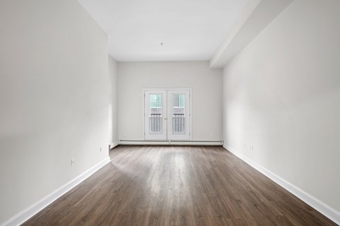 an empty living room with white walls and wood floors