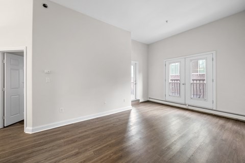 an empty living room with white walls and wood floors