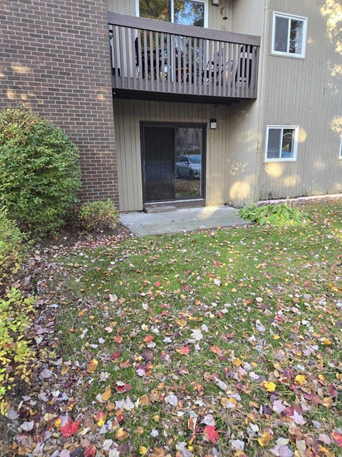 a yard with leaves on the ground in front of a house