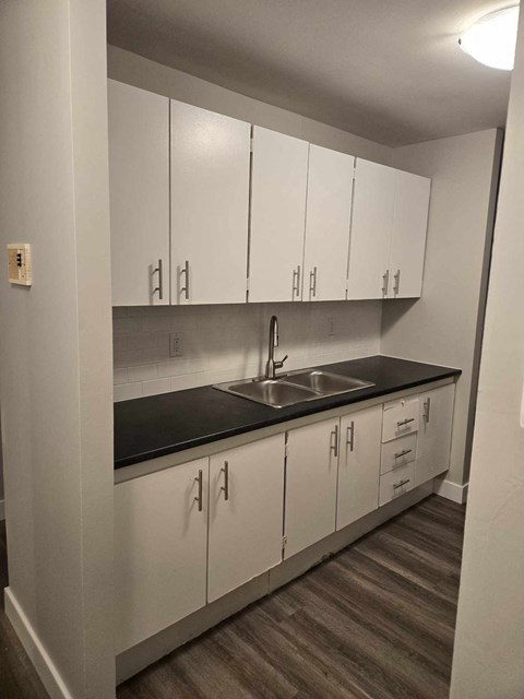 a kitchen with white cabinets and a sink
