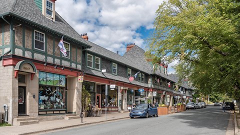 A street view of a small town with a car parked on the side of the road.