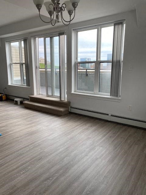 an empty living room with windows and a wooden floor