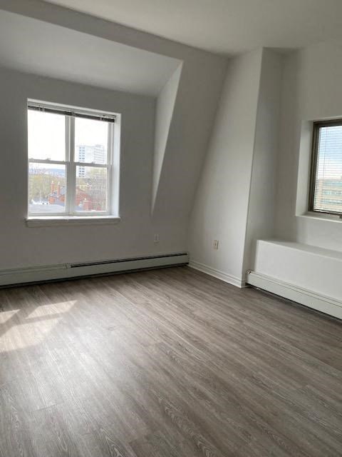 an empty room with a wood floor and a window