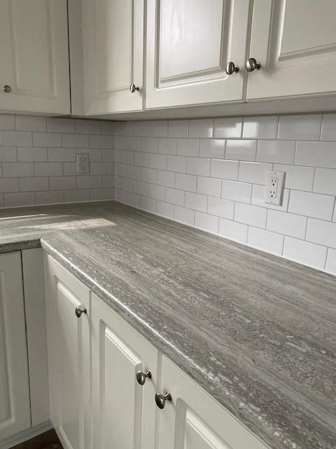 a kitchen with white cabinets and a counter top