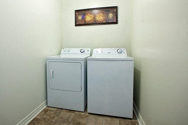 two washes and dryers in a room with a painting on the wall