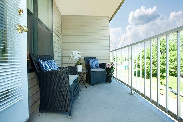 a porch with two chairs and a table on it