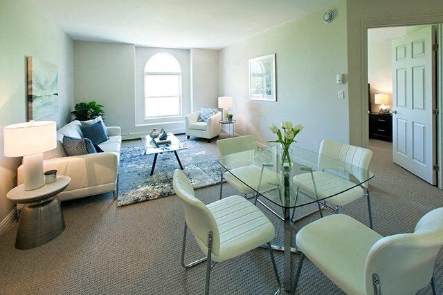a living room with a glass table and chairs