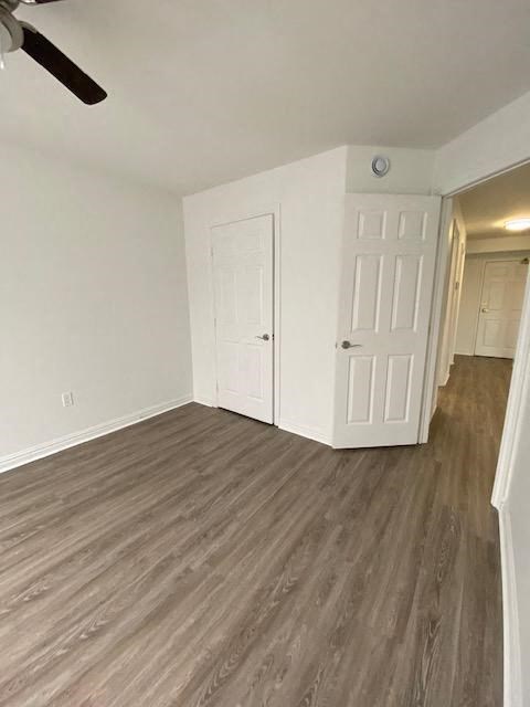 an empty living room with a wood floor and a white door