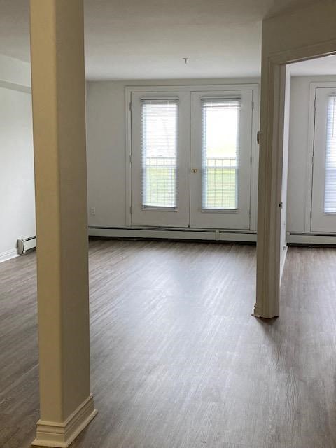 an empty living room with white walls and wood floors