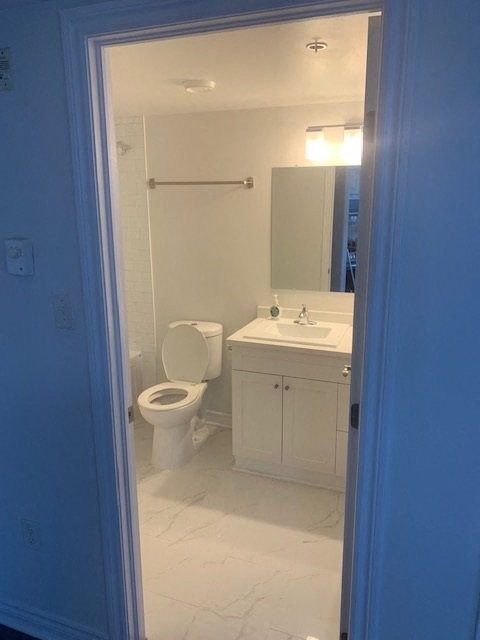 a white bathroom with a toilet and a sink