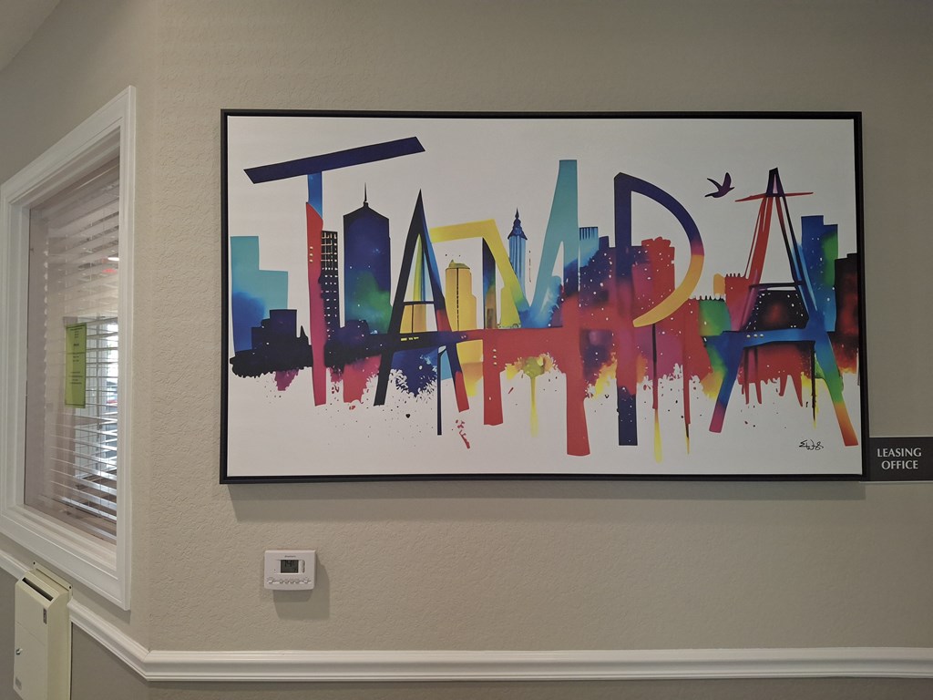 A colorful painting of a city skyline with the word "TAMPA" written across it. Madison Highlands 2 Art in Tampa Florida.