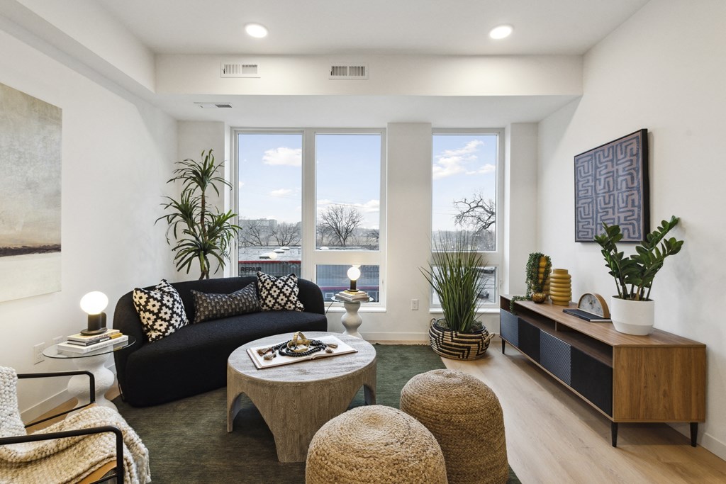 a living room with a couch and a coffee table and large windows