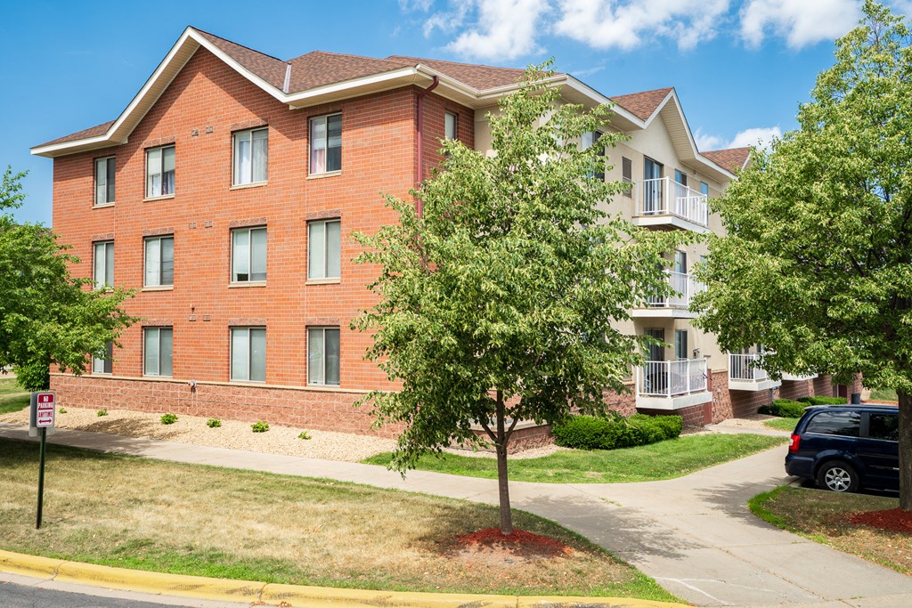 a large brick apartment building with a tree in front of it