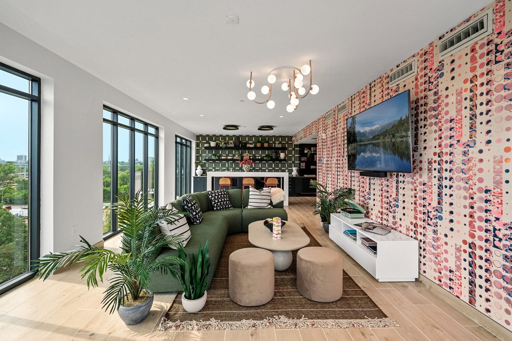 clubroom with a green couch and a television on the wall