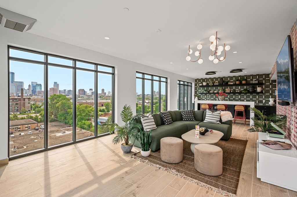 a community space with a green couch and a view of the city