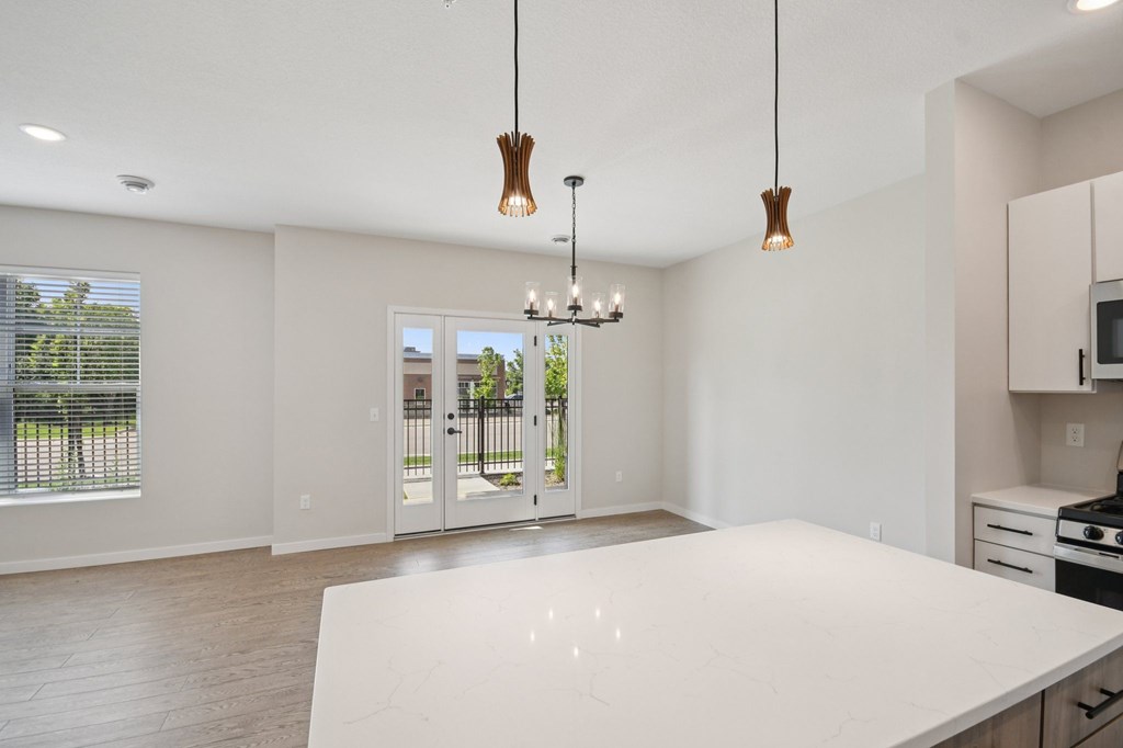 A modern kitchen with a large island and pendant lights at Ironwood Townhomes in Medina, Minnesota..