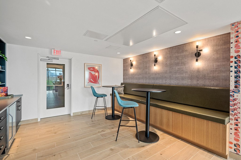 a bar with three stools in a room with a counter and a door