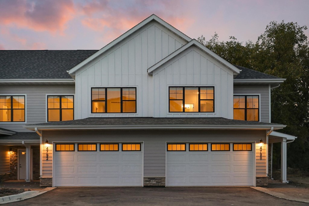 A house with a white garage door and a grey roof.