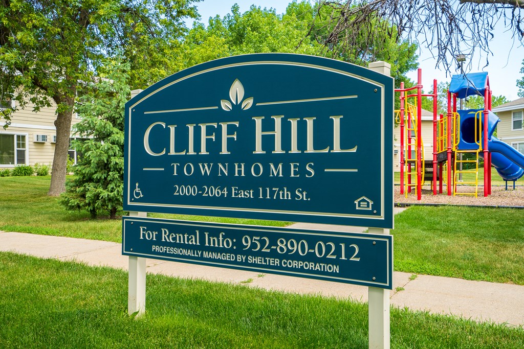 a sign townhomes in front of a playground