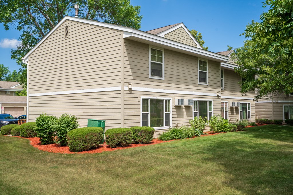 a home with a lawn and landscaping in front of it