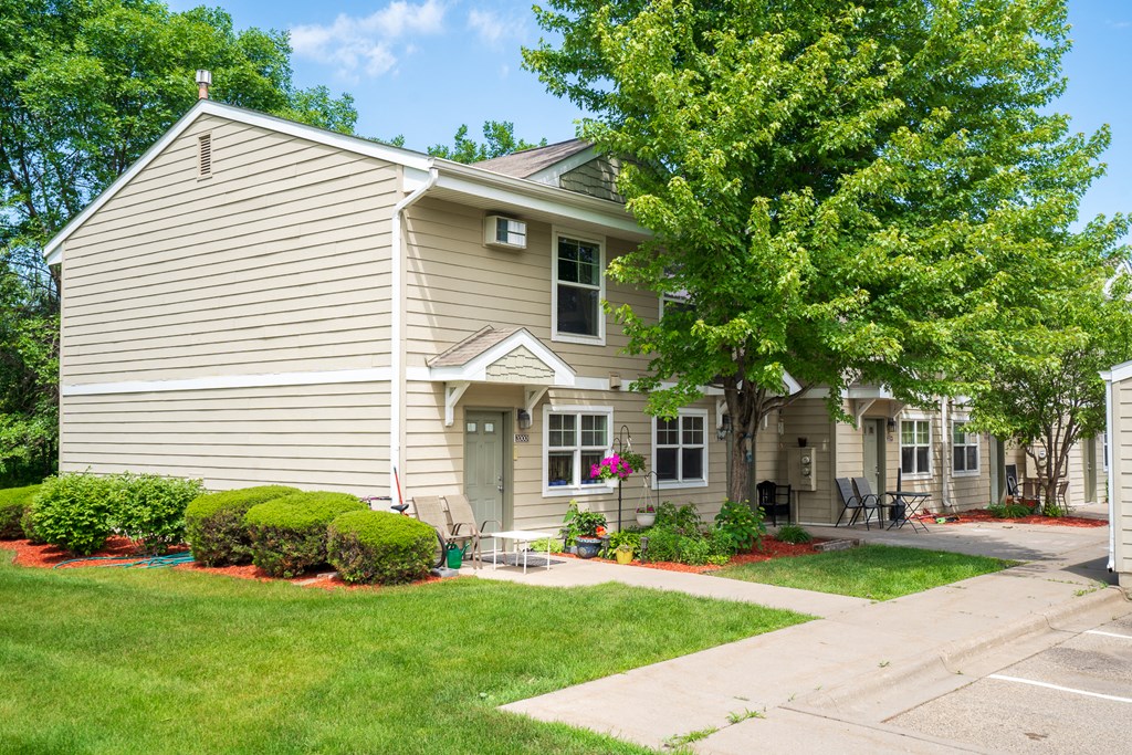 a house with a lawn and trees in front of it