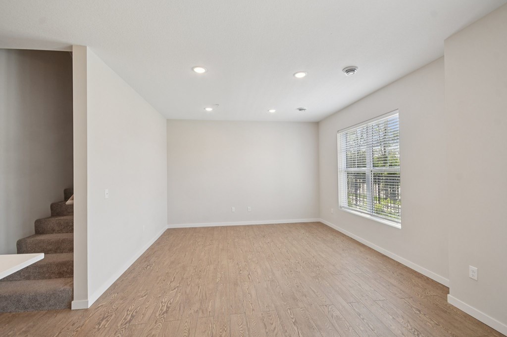 Living Room with wooden flooring and a staircase on the left side at Ironwood Townhomes in Medina, Minnesota.