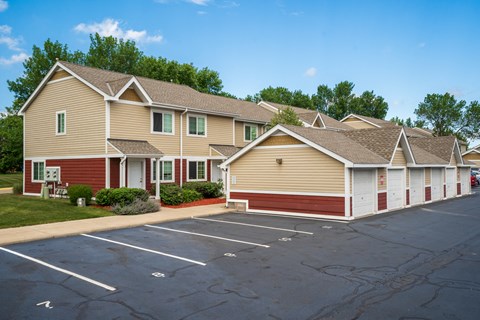 an empty parking lot in front of a row of houses