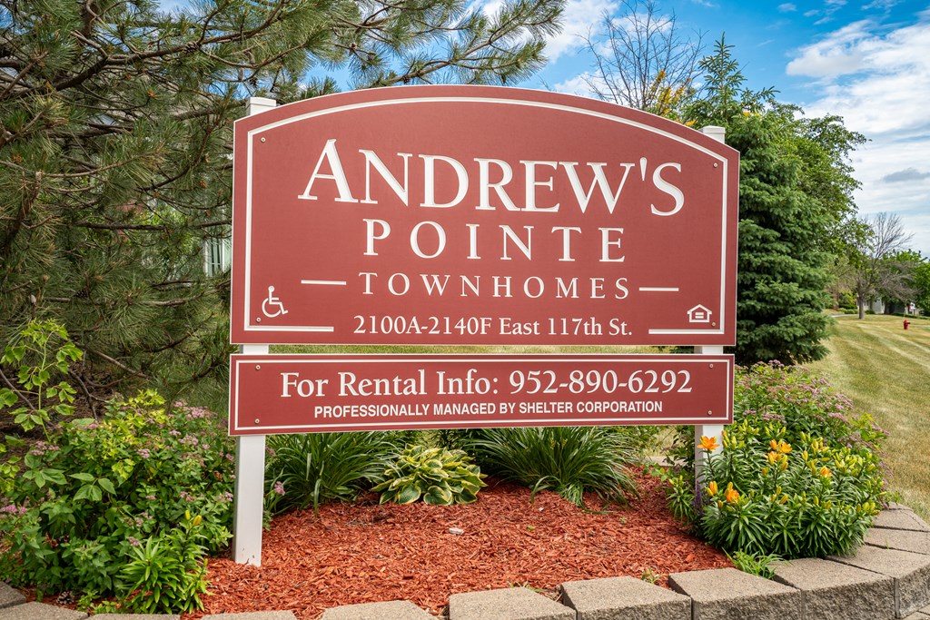 a sign townhomes in front of a park