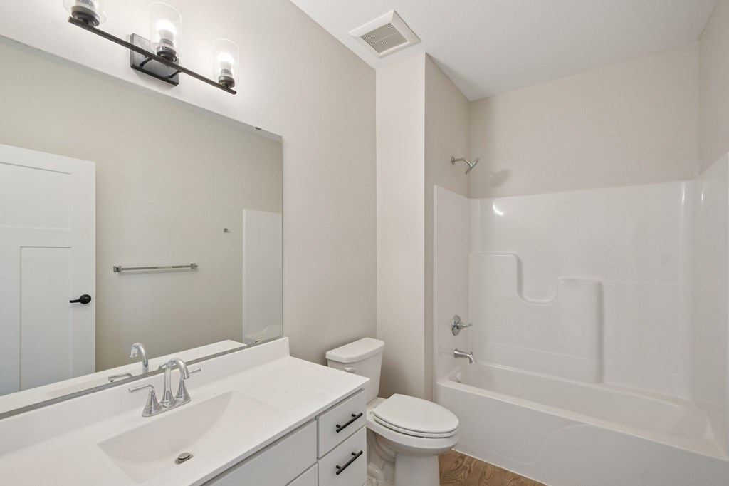 A white bathroom with a sink, toilet, and bathtub.